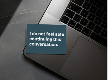 A dark blue script card is resting on a laptop. It reads: 'I do not feel safe continuing this conversation'